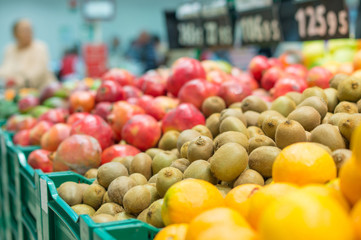 Variety of kiwi fruits and pomegranate fruits in boxes in superm