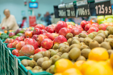 Variety of pomegranate fruits and kiwi fruits in boxes in superm