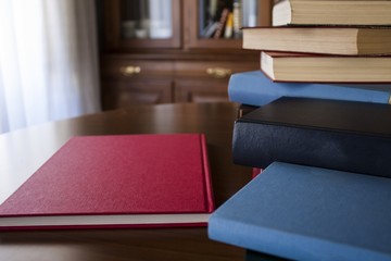 Many different sized colored and shaped books on wood table