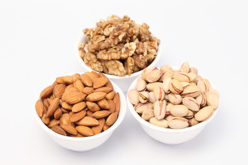Bowls of almonds,walnuts and pistachios on white background