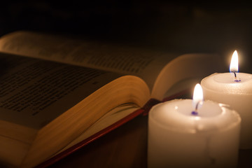 open book and candles on wood table
