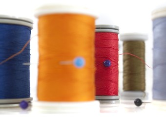 different thread reels on white background