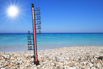 Thermometer on a beach shows high temperatures