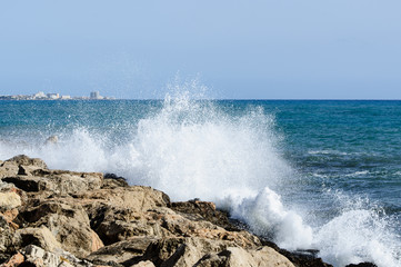 Fototapeta na wymiar Sea waves breaks at rock coastline