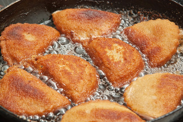 Patties with calamaries in butter in a frying pan.