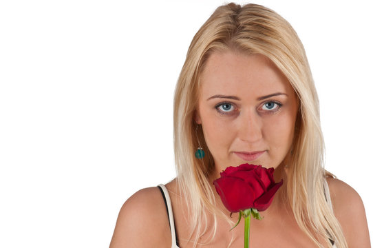 Romantische junge Frau riecht an roter Rose