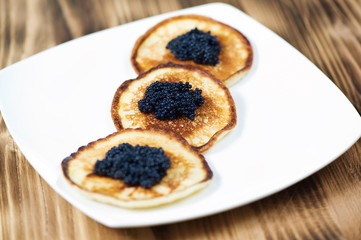 Pancakes with black caviar