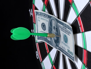 Dollar on bulls eye. Darts  close-up on black background