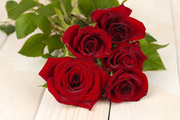 bouquet of red roses on a white wooden table close-up