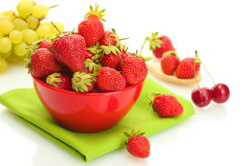 sweet ripe strawberries in bowl and grapes isolated on white