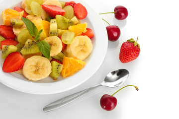 Fresh fruits salad on plate and berries isolated on white