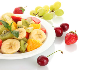 Fresh fruits salad on plate and berries isolated on white