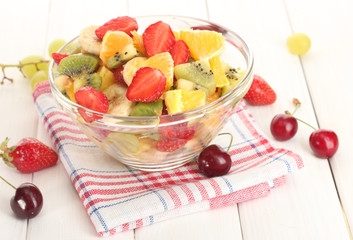 glass bowl with  fresh fruits salad and berries