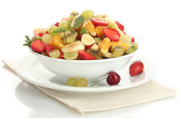 bowl with fresh fruits salad and berries isolated on white