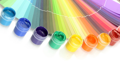colorful jars with gouache on a palette background close-up