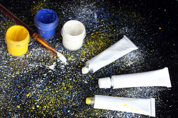 Jars with colorful gouache, brush and tubes with colorful
