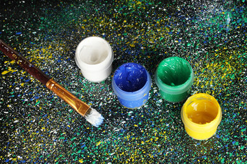 Jars with colorful gouache and brush