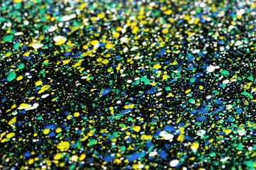 Bright splashes of paint on black background close-up