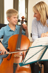 Boy playing cello in music lesson © Monkey Business