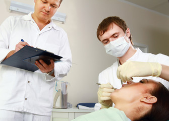 Young woman with dentist in a dental surgery.