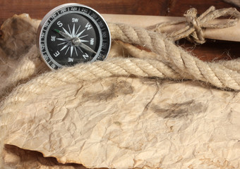 Fototapeta na wymiar stary papier, kompas i liny na drewnianym stole