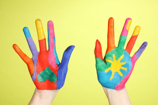 Brightly colored hands on green background
