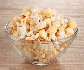 popcorn in glass bowl on wooden table
