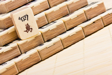 Old chinese game mahjongg on bamboo mat background