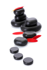 Spa stones and red petals isolated on white