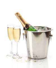 Champagne bottle in bucket with ice and glasses of champagne,