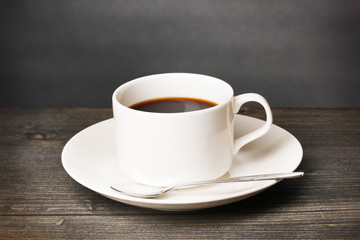 Coffee cup on wooden table on grey background