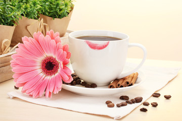 cup of coffee with lipstick mark and gerbera beans, cinnamon