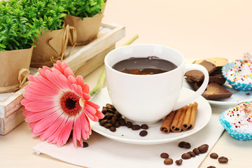 cup of coffee and gerbera  beans, cinnamon sticks