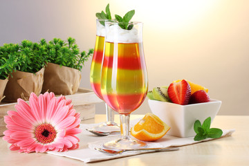 fruit jelly in glasses and fruits on table in cafe