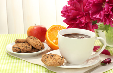 hot chocolate, fruits, cookies and flowers in cafe