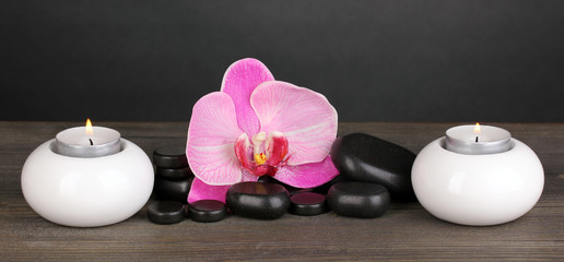 Obraz na płótnie Canvas Spa stones with orchid and candles on table on grey background
