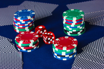 Playing cards and dice with poker chips on table