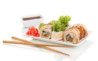 Tasty rolls on plate with chopsticks isolated on white