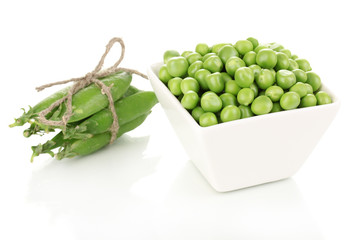 Green peas in glass bowl isolated on white