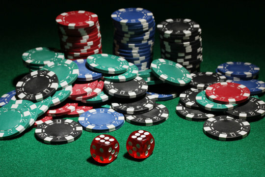 Dices and chips for poker on green table