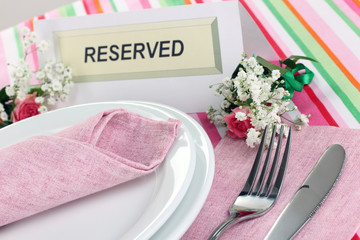 Table setting with reserved card in restaurant