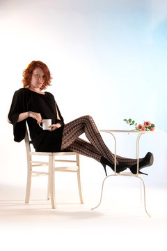 Eine Frau sitzt entspannt und streckt lange Beine aus