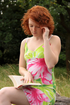 Eine junge Frau beim Lesen mit Buch