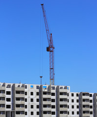 red crane and blue sky on building site