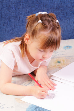 Attractive little girl draws picture