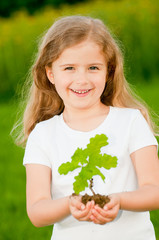 Environmental protection - kid and young plant of a oak