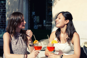 two young girls while they take a cocktail
