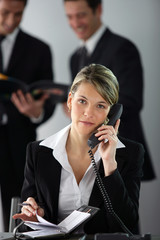 businesswoman making call whilst colleagues