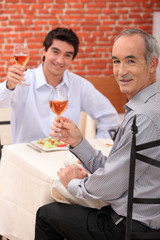 Young man at a restaurant with his grandfather