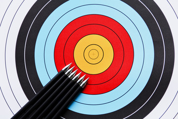Six arrows pointing to the center of an archery target